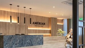 A modern reception desk with a marble top and wooden paneling. - Amerian Chacras de Coria (Chacras de Coria)