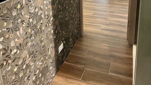 A hallway with a patterned wall, a wooden floor, a bed with a canopy, and a wardrobe. - Domus Ballà Tonale Camera 1 (Verona)