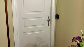 A closed white door with a silver handle and a keyhole.