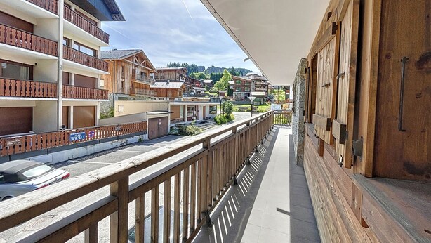 Un balcon donnant sur la ville, avec des balustrades en bois et un ciel dégagé.
