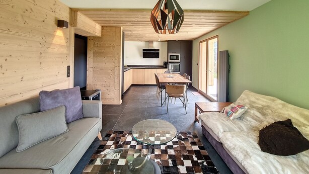 Una sala de estar moderna con un sofá, una mesa de centro y una alfombra estampada.