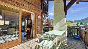 Enjoy a peaceful retreat with a balcony overlooking the scenic landscape, featuring a glass door leading to a cozy interior space with a table and chairs.