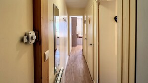 A hallway with wooden flooring, a radiator, and a ceiling light fixture. - Ceylan - appartement - 5 pers - centre (Les Gets)