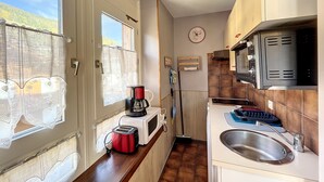 A compact kitchen with a microwave, toaster, coffee maker, and a sink. - Ceylan - appartement - 5 pers - centre (Les Gets)