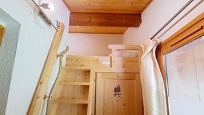 A wooden staircase with a built-in shelf and a decorative door with a tree emblem.