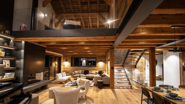 A modern interior with a wooden ceiling, a piano, sofas, a dining area, and a staircase. - Chalet Caly - 15pers - vue montagne (Les Gets)