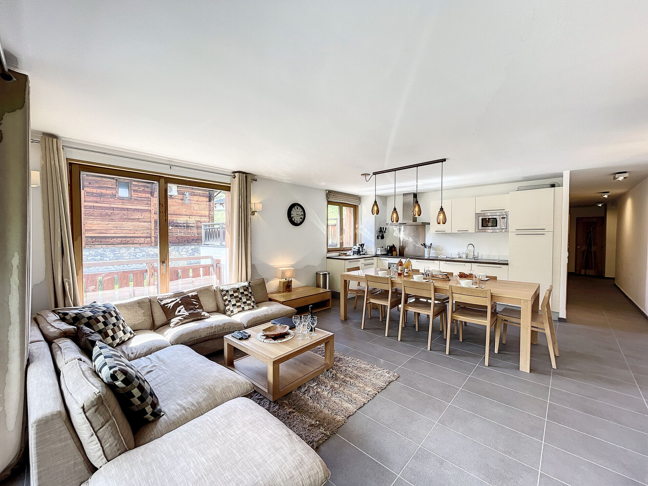 A modern living room with a sofa, coffee table, and dining area.