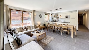 En moderne stue med sofa, sofabord og spiseplads.