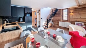 A modern kitchen with a built-in oven and a dining area with a table set for two.
