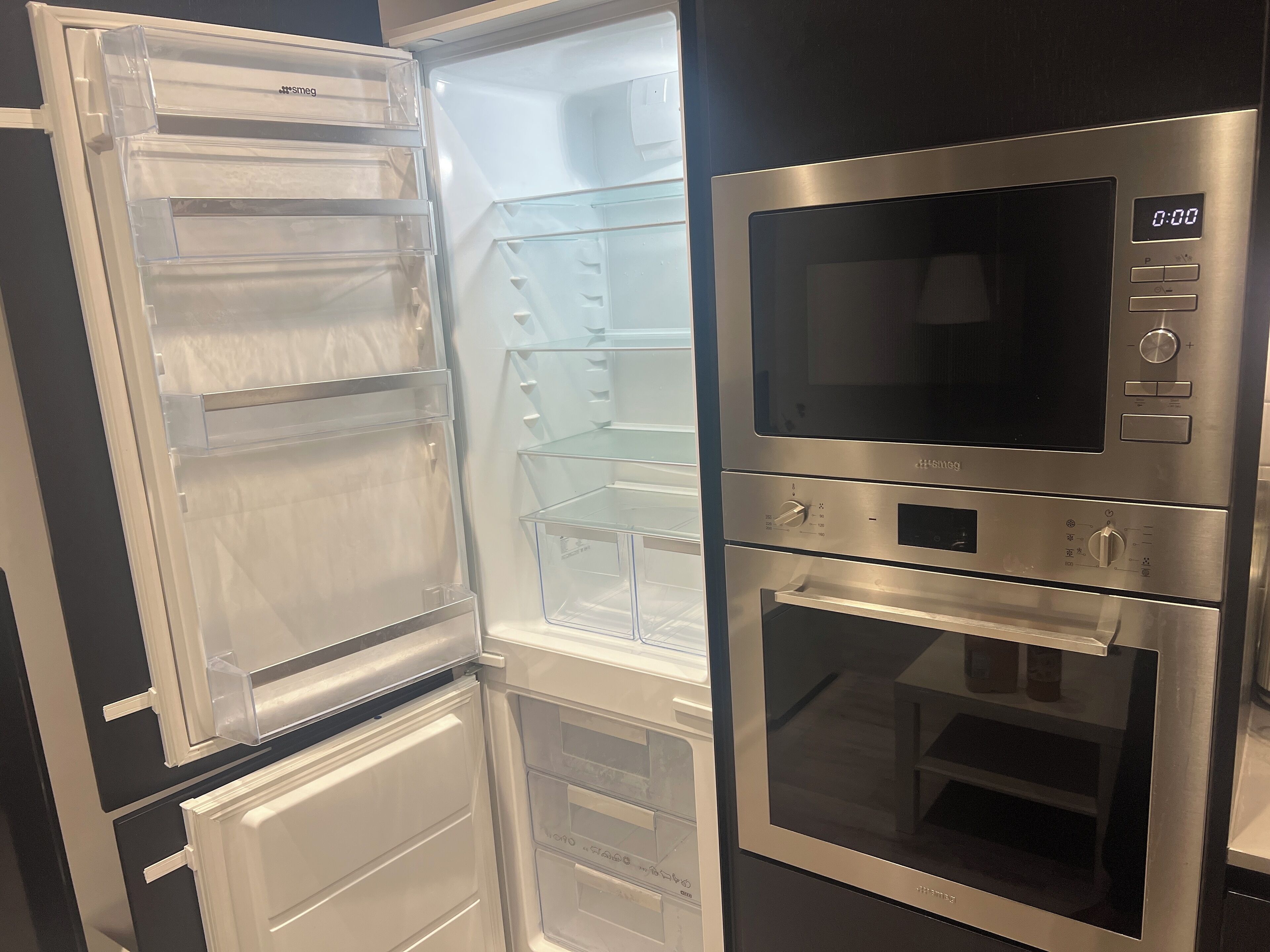 A stainless steel refrigerator with a built-in microwave and oven, featuring multiple shelves and compartments.