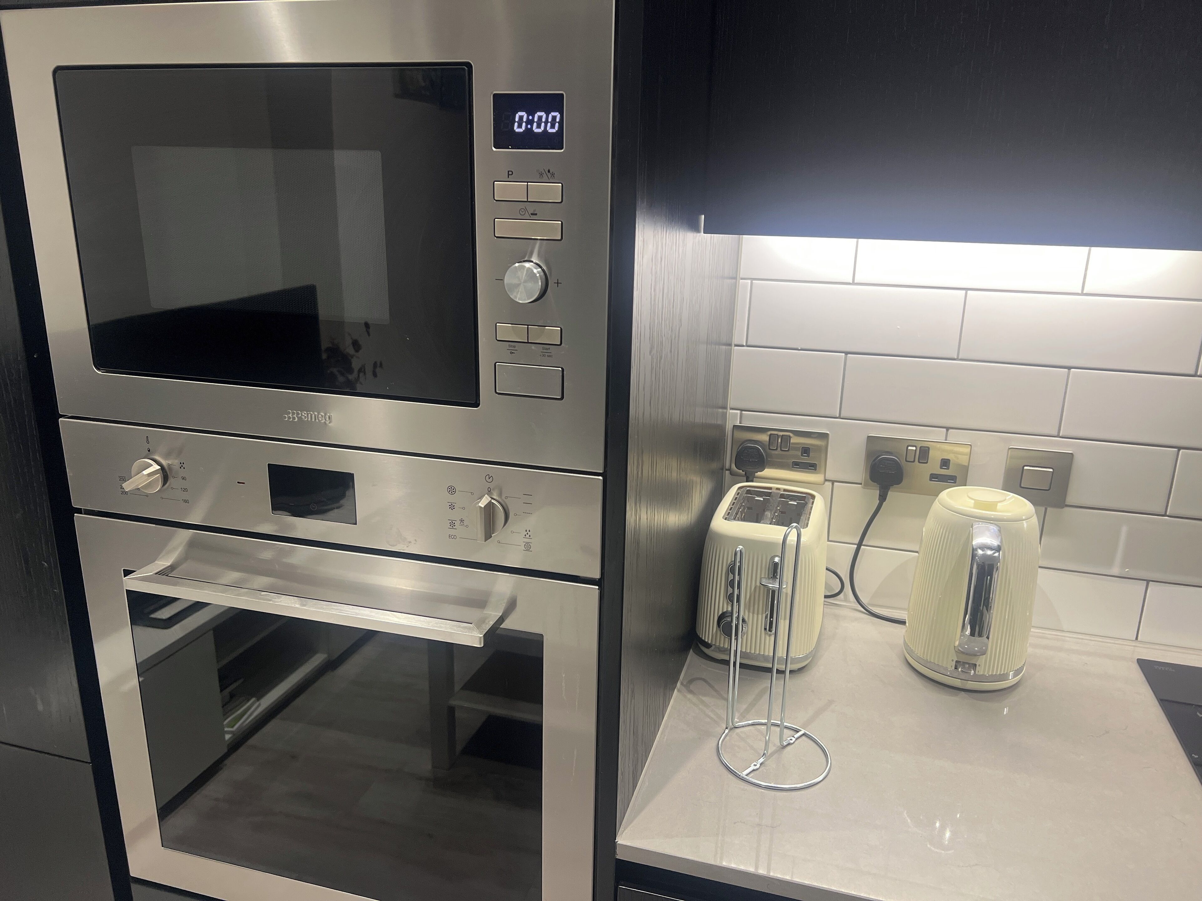 Una cocina equipada con microondas, horno y tostadora.