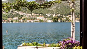 A view of a lake with houses on the shore, a lamp post, and a flower bed. - Art Apartment Seasoul (Dubrovnik)