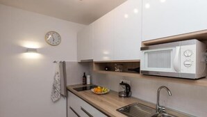 Eine moderne Küche mit Mikrowelle, Spüle und einer Holzausziehtafel.