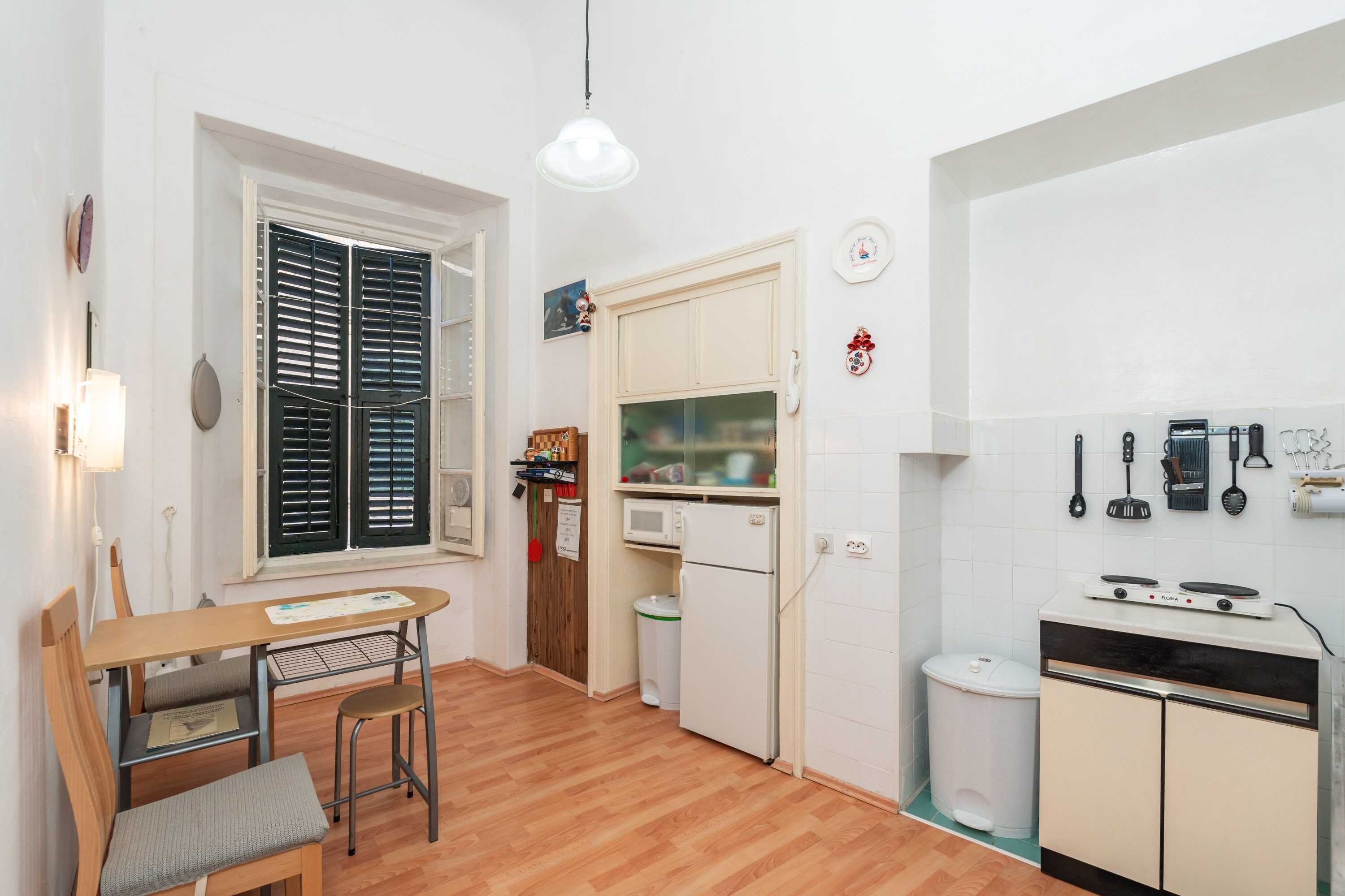 A compact kitchen with a dining area, a microwave, a refrigerator, and a stove.