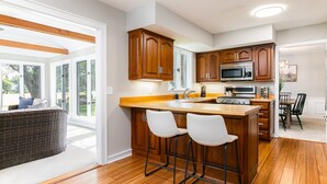 Una cocina moderna con armarios de madera, una isla grande con taburetes de bar, un microondas y una estufa.