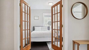 Un dormitorio con una cama, una mesita de noche y un espejo en la pared.