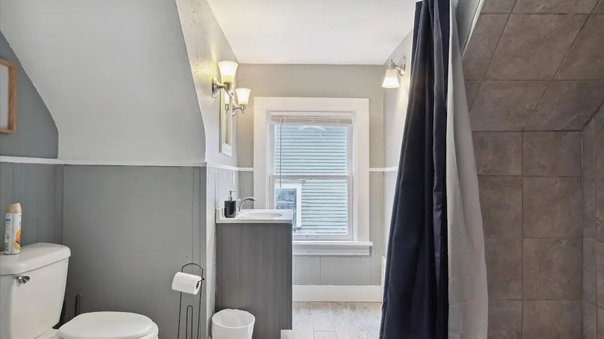 Une salle de bain avec des toilettes, un lavabo et une fenêtre.