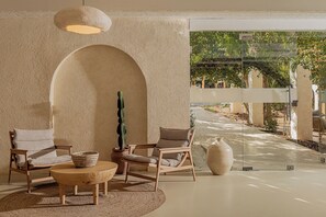 A room with two wooden chairs, a woven basket, a large vase, and a hanging light fixture. - Serab Residencia (Jounieh)