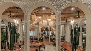 A restaurant with wooden tables, wicker chairs, and cacti. - Serab Residencia (Jounieh)