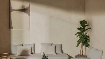 A modern living room with a sofa set, a coffee table, and a potted plant.