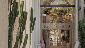 A building entrance with a clear view of the interior through a glass door, featuring a sign that reads "RESIDENCIA". - Serab Residencia (Jounieh)