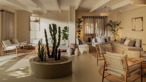 A modern living room with a central planter, sofas, and wooden chairs. - Serab Residencia (Jounieh)
