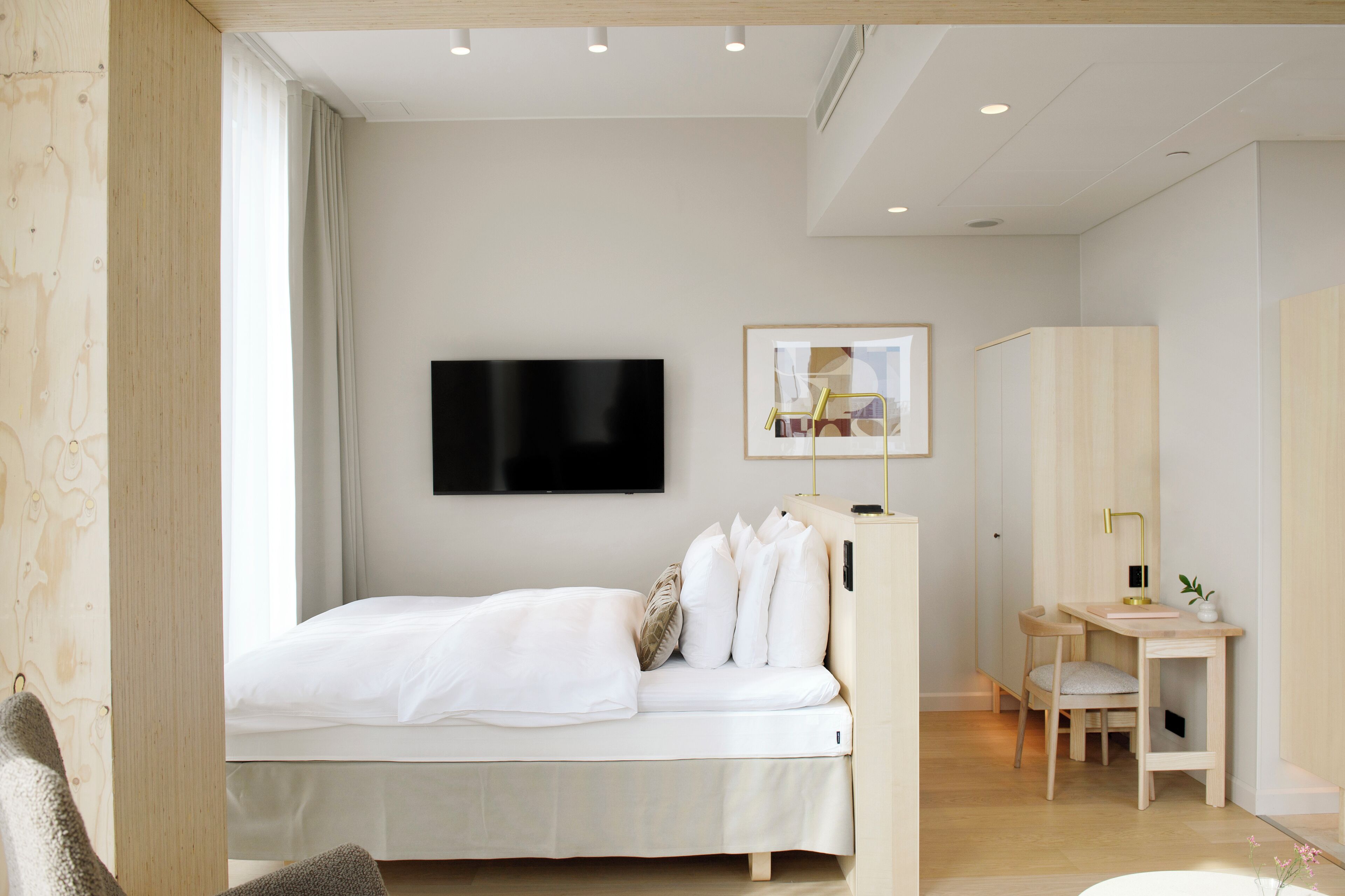 Quarto moderno com cama, escrivaninha e cadeira.