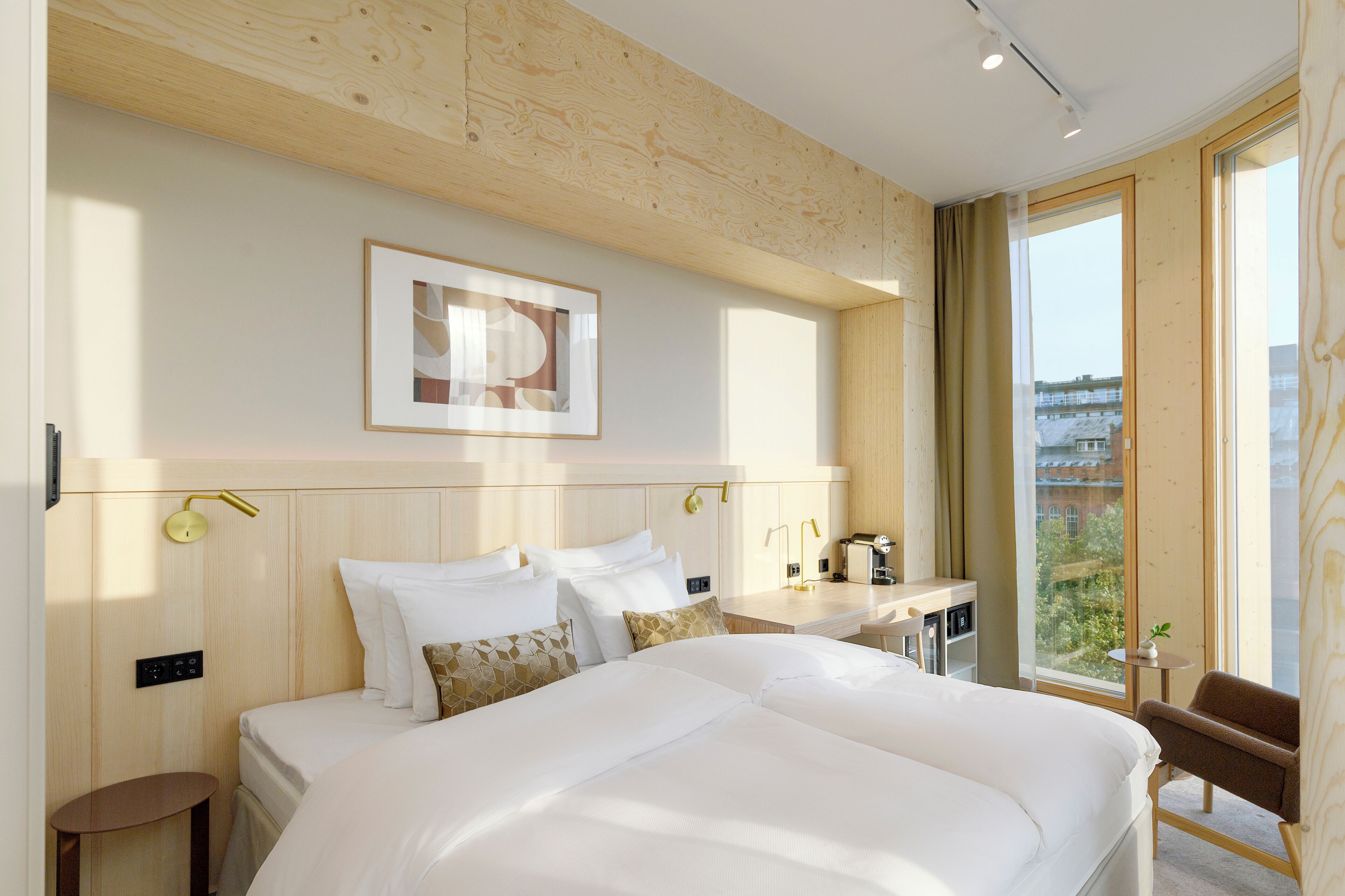 Une chambre d’hôtel moderne dotée d’un grand lit, d’un bureau et offrant une vue sur la ville.