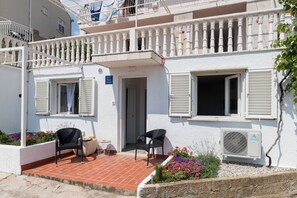 A two-story building with a balcony, a door, and a window with shutters. - Apartment Semi (Dubrovnik)