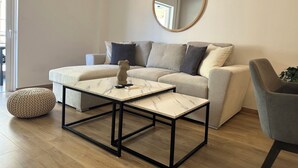 Un salon moderne avec un canapé, une table basse et un fauteuil.