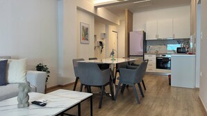 Un salon moderne comprenant un coin repas, une cuisine et un couloir.