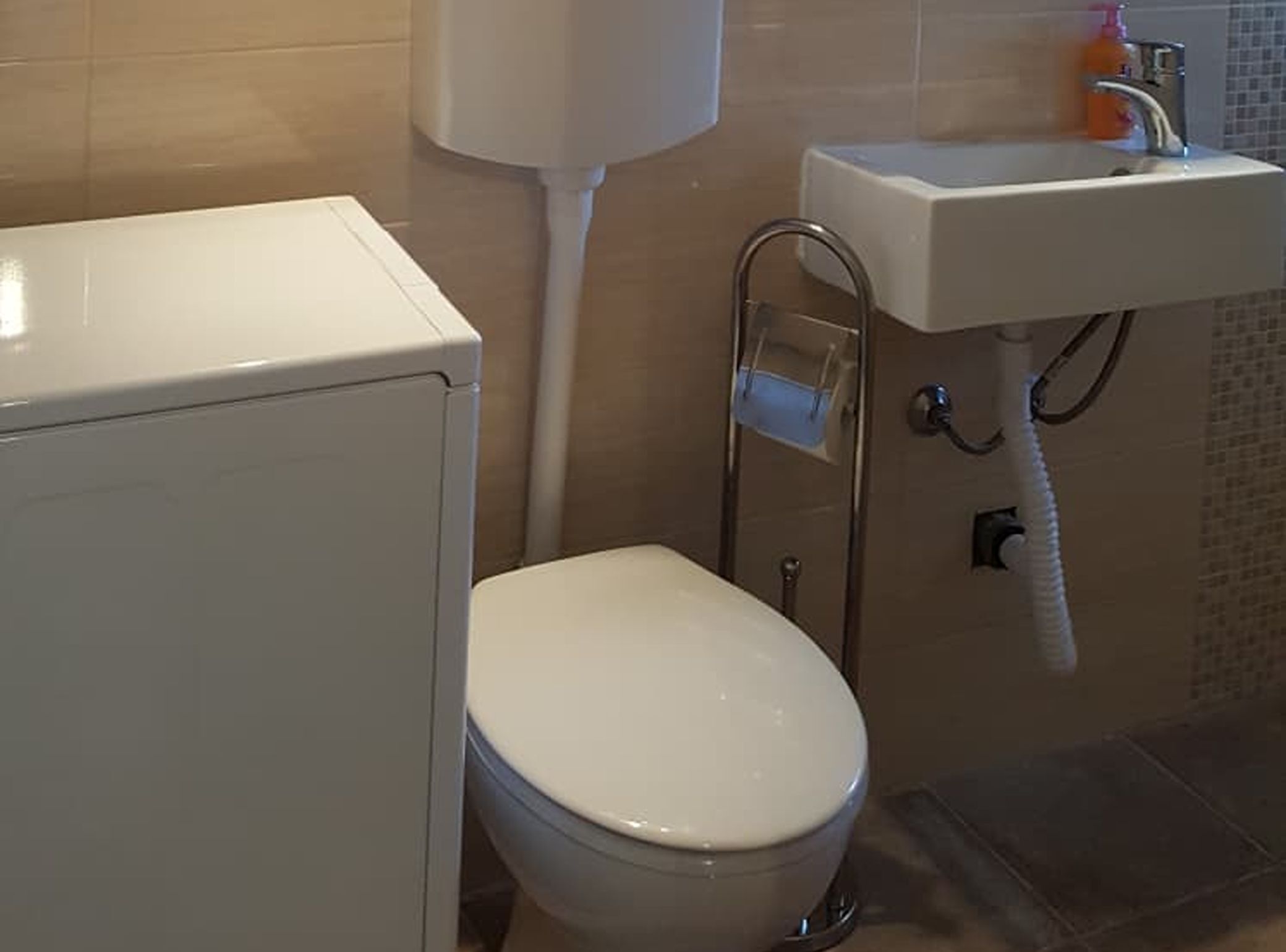 Une salle de bain avec des toilettes, un lavabo et une douche.