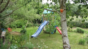 Ein Spielplatz mit Rutschen und einer hölzernen Kletterkonstruktion.