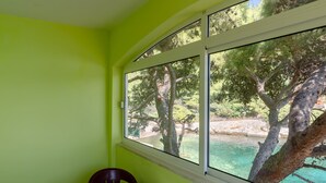 A room with a large window overlooking a natural landscape. - Seafront Apartments Olivera (Blato)