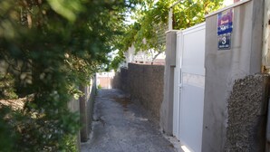 A narrow alleyway with a concrete wall on one side and a metal gate on the other. There is a sign above the gate that reads "SOBE" and "3". - Serious Job Room (Dubrovnik)
