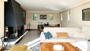 A living room with a sofa, a coffee table, a TV, and a fireplace. - "La Villa du Cap - Sea view - 2/8 travellers (Fécamp)