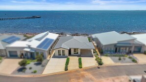 A coastal residential area with modern houses, a pier, and a clear view of the sea. - Sea La Vie - Absolute beachfront!  Amazing sea views! Off peak special! (Port Victoria)