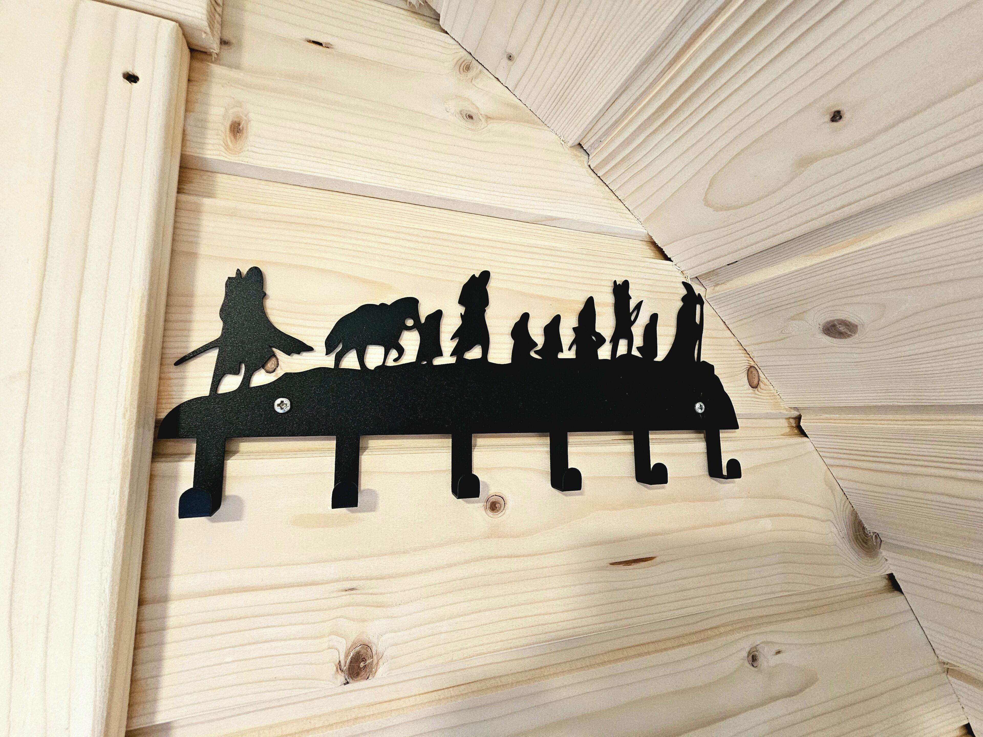 A wooden wall with a silhouette cutout of a family and animals.
