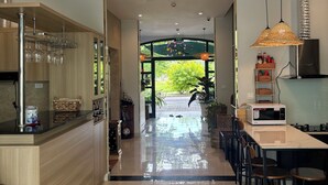 A modern kitchen with a central island, a dining area with chairs, and a view of the outdoors.