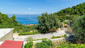 A coastal view with a stone pathway leading to a building with a red roof. - Vacation House Marija, Korčula (Korcula)