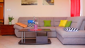 Un salon comprenant un canapé, une table basse et deux tableaux accrochés au mur.
