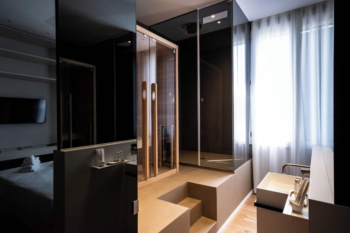 Un baño moderno con cabina de ducha de vidrio, un lavabo y un espejo.