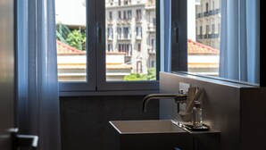 A modern bathroom with a large window, a sink, and a towel rack. - Amorgiù Luxury Room (Palermo)