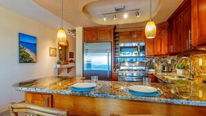 A kitchen with a granite countertop, wooden cabinets, and a built-in oven.