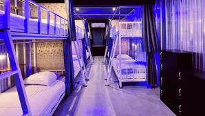 Una habitación con literas, paredes de madera y techo oscuro.