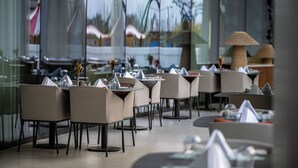 A modern restaurant with multiple tables and chairs, large windows, and a view of the outside. - The Land of Legends Nickelodeon Hotels Antalya (Serik)