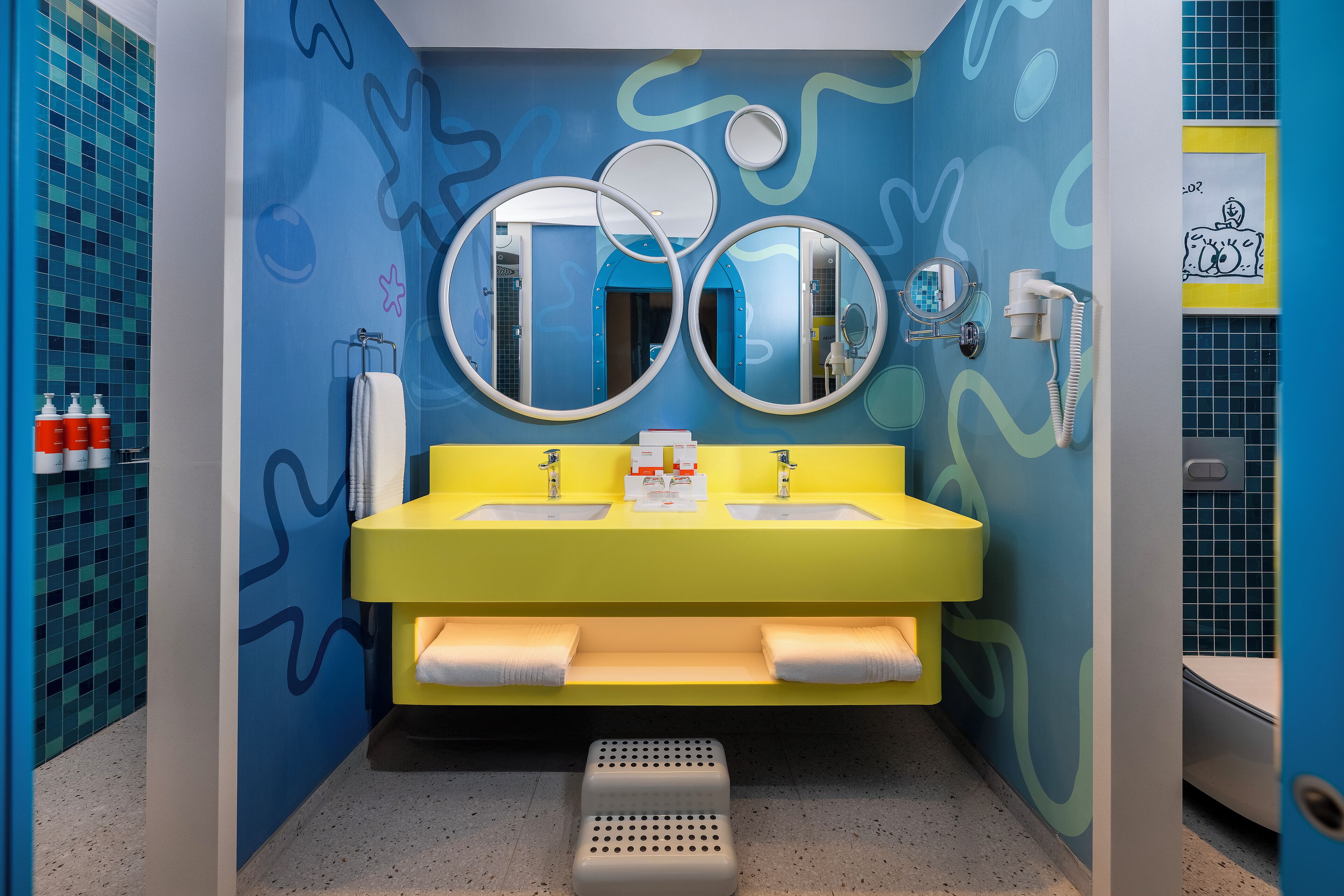 A bathroom with two sinks, a mirror, and a towel rack.