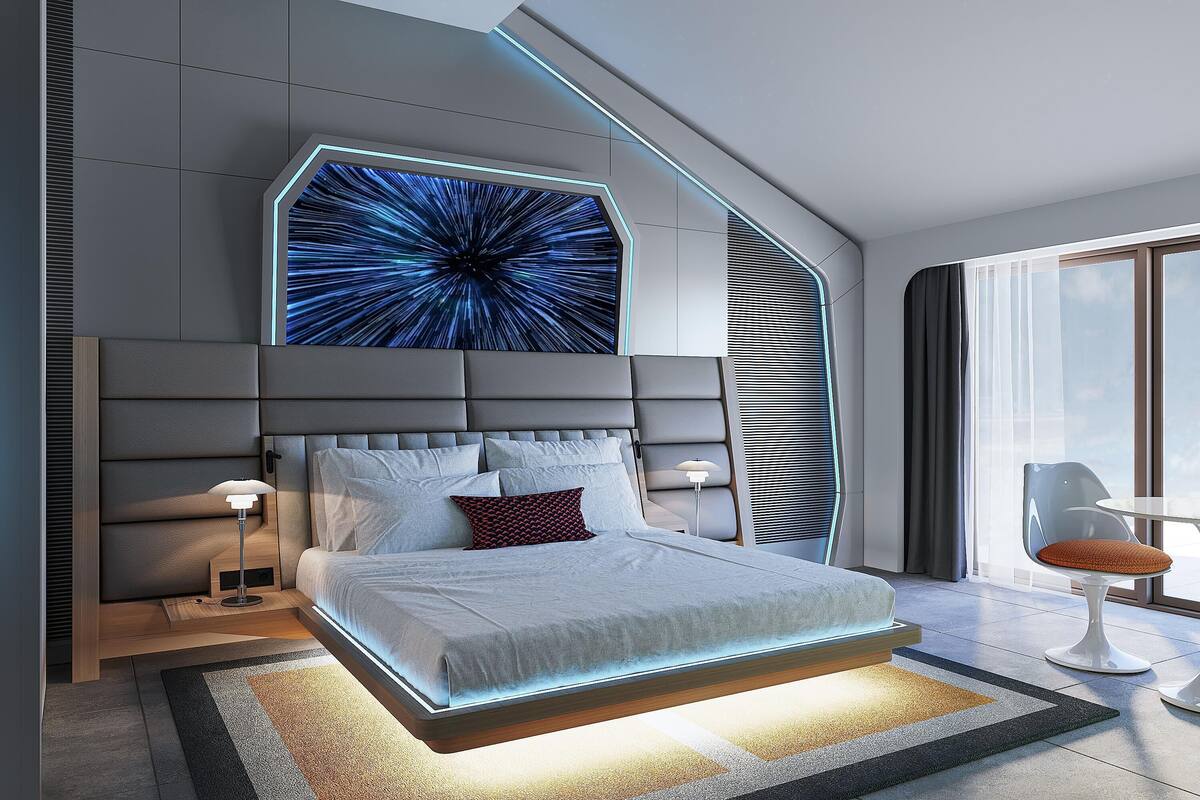 Un dormitorio moderno con una cama grande, una pantalla digital en la pared y vista al cielo a través de una ventana.