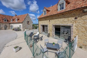 A courtyard with outdoor seating and a stone building with a tiled roof. - Vacation home with a heated indoor pool on the Opal Coast (Tingry)