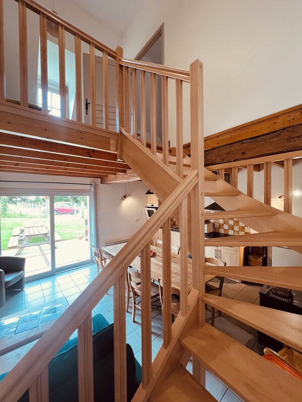 Un escalier en bois à plusieurs niveaux reliant différentes parties d’une maison.